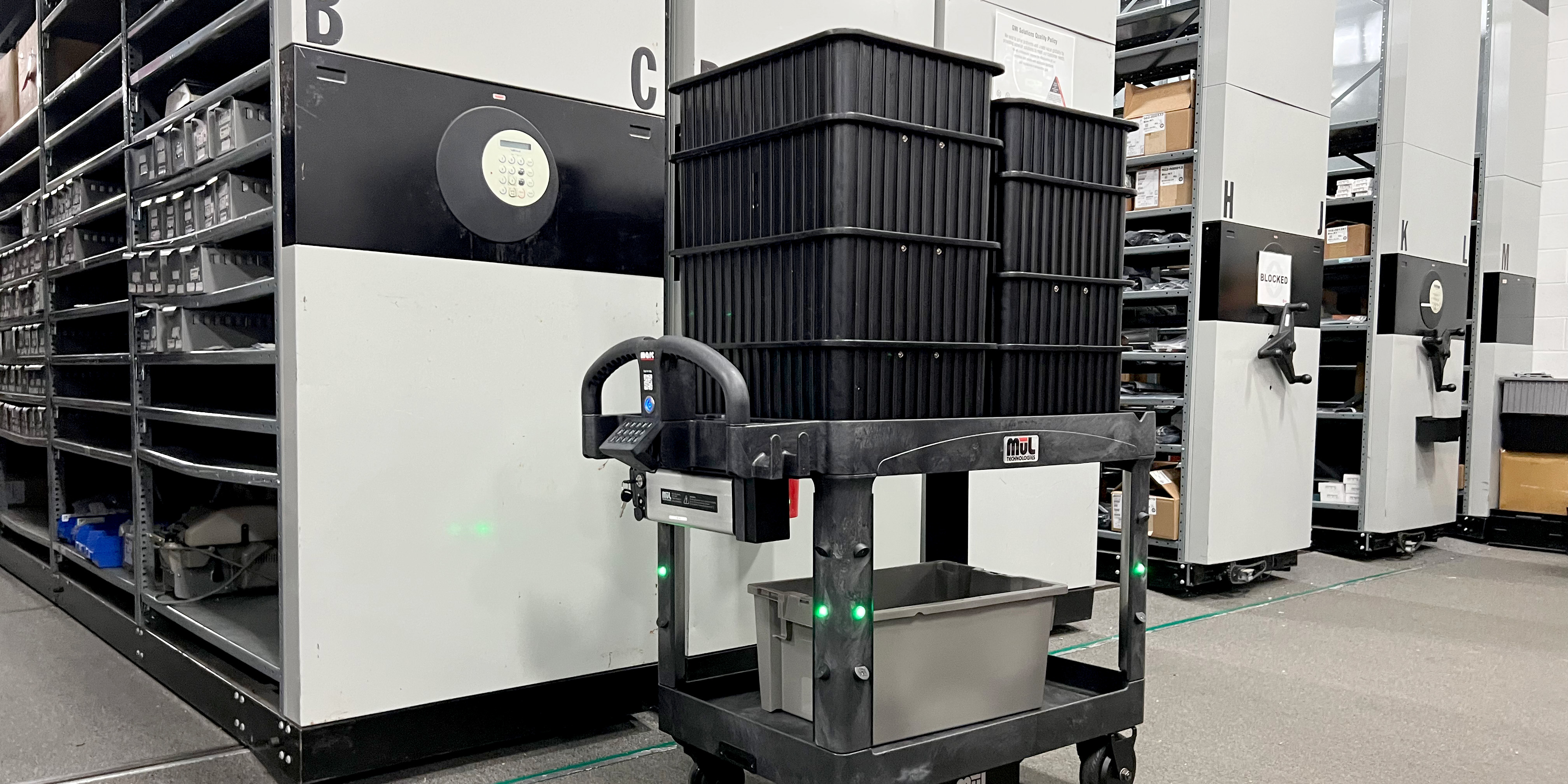 An autonomous robotic cart is loaded with bins.