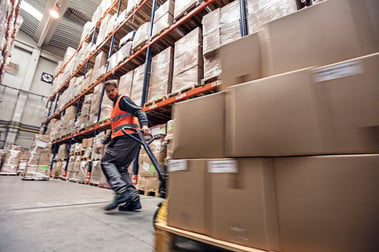 man moving boxes in a warehouse