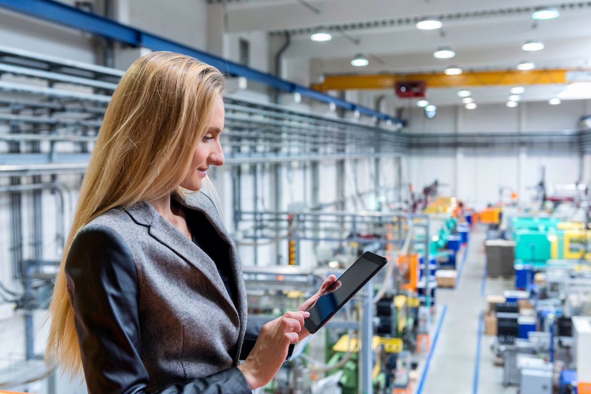 Satisfied warehouse manager looking at tablet. 